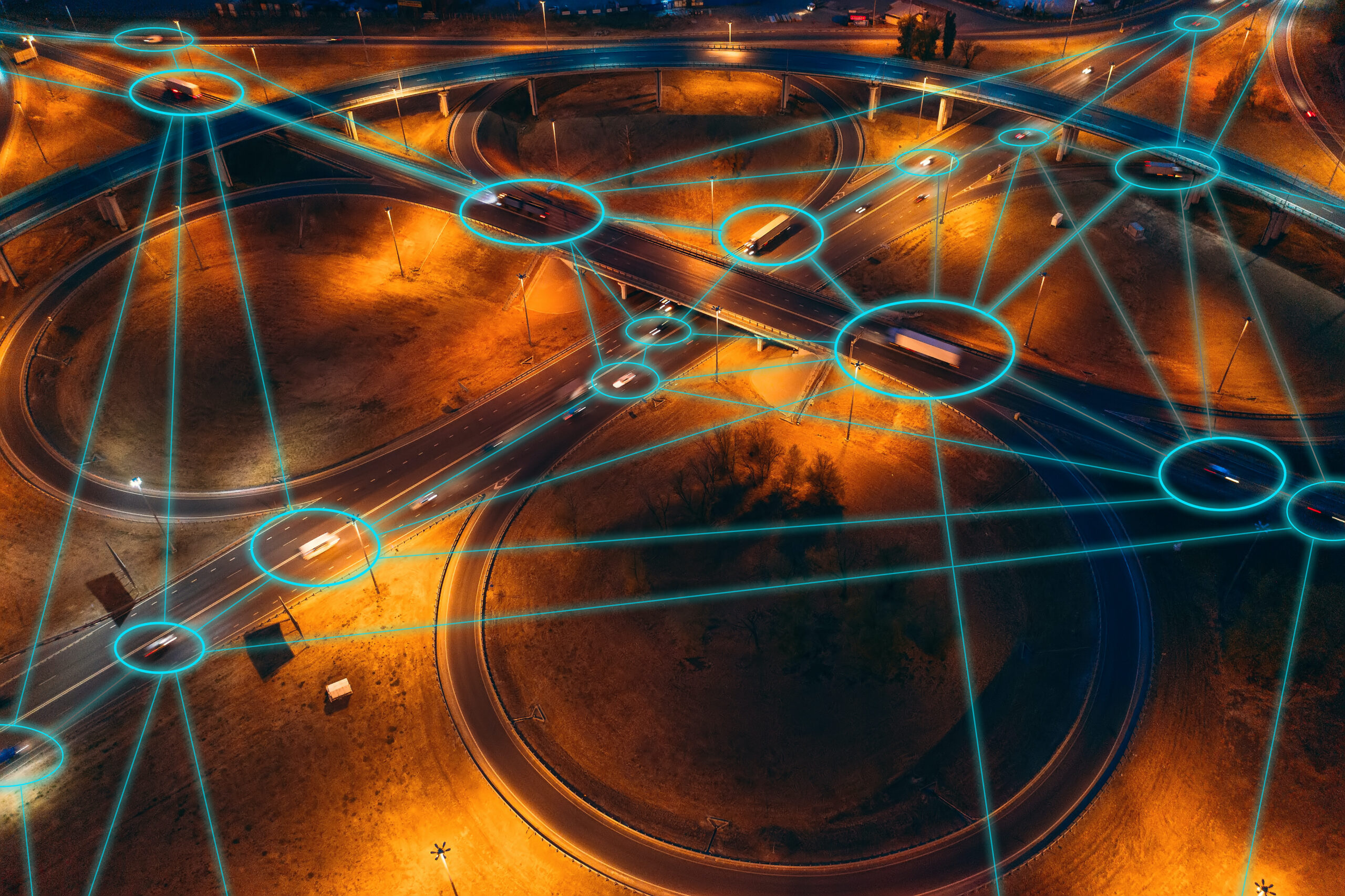Aerial view of a motorway interchange with connected vehicle tracking overlays.