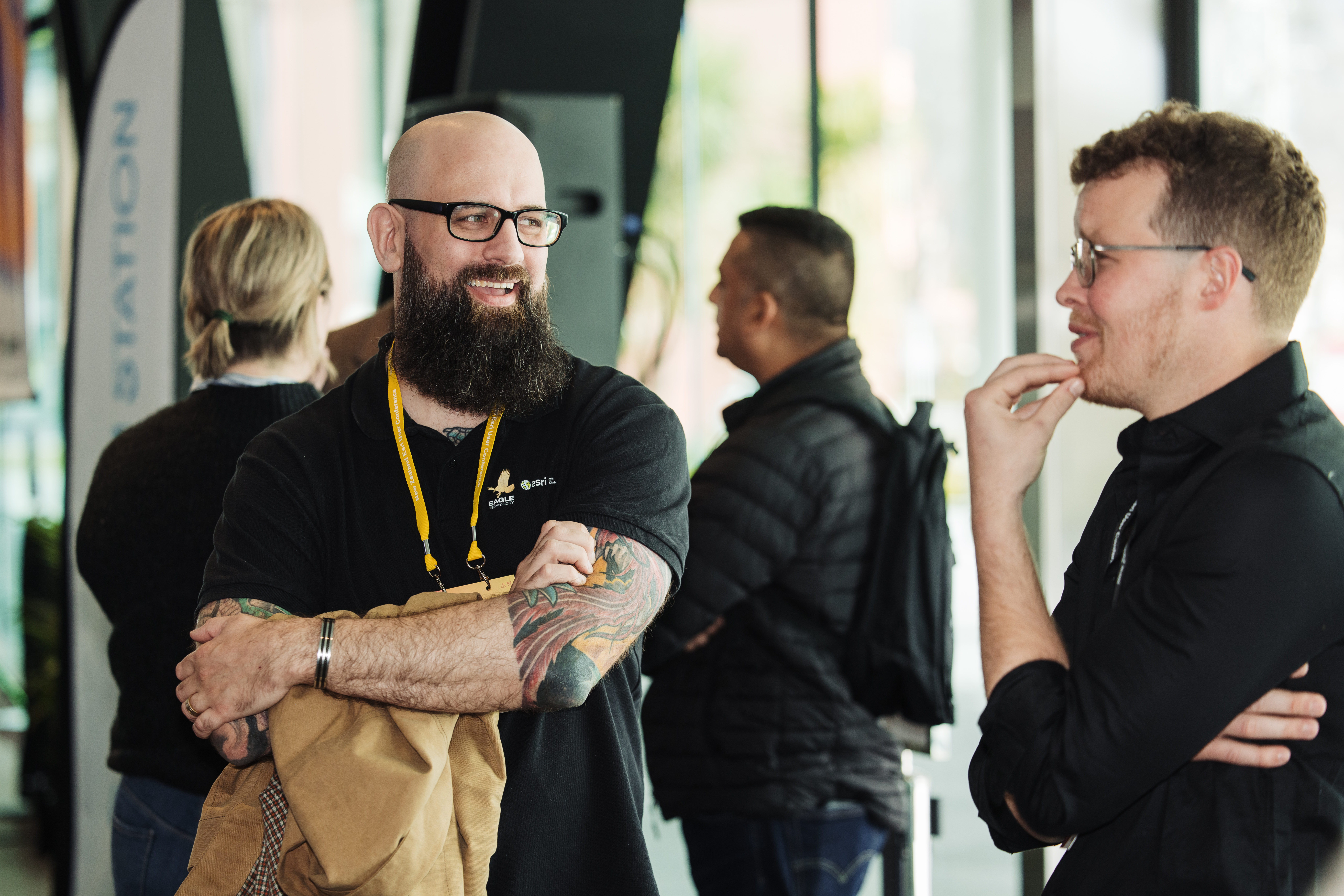 Two men attending conference laugh together.