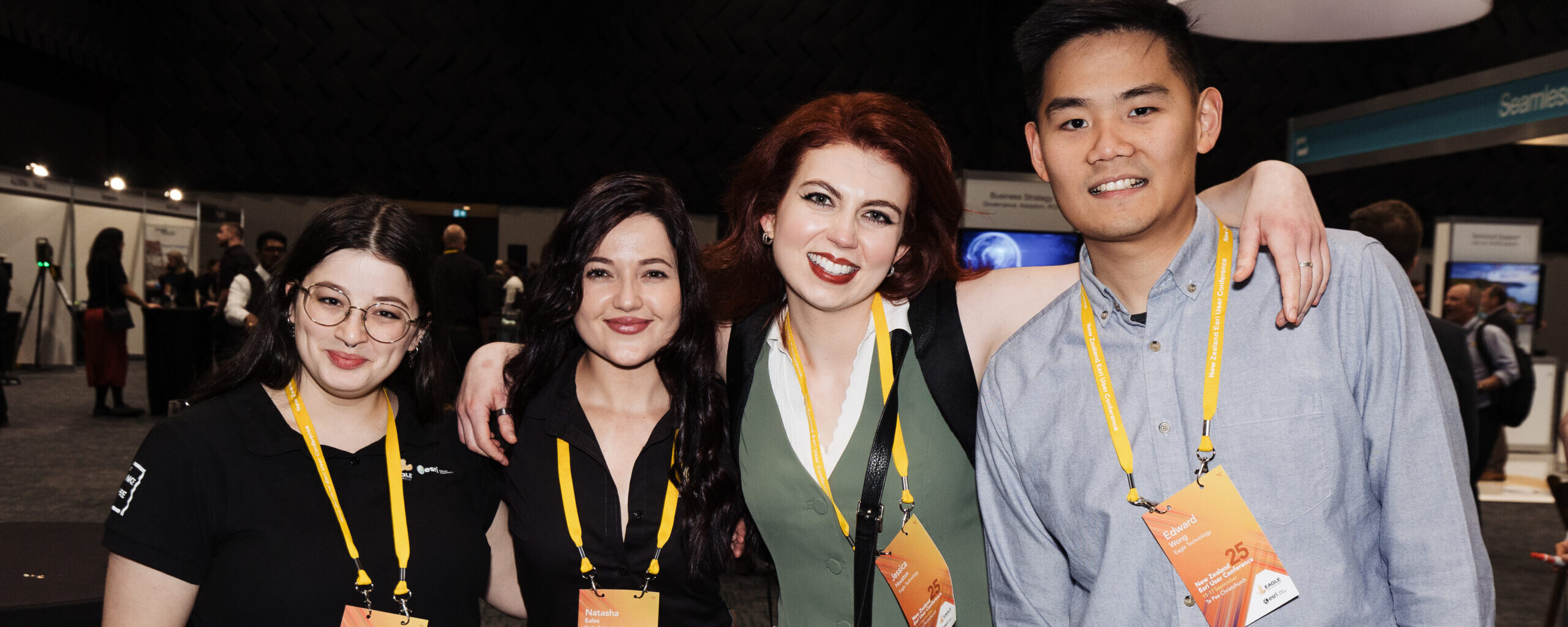 Conference-goers with lanyards pose for a group picture.